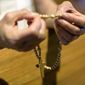 A member of the St. Thomas Korean Catholic Center prays the rosary in Anaheim, Calif. (Associated Press/File)