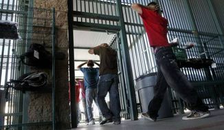 **FILE** Illegal immigrants file into a U.S. Border Patrol facility in Tucson, Ariz. (Associated Press)