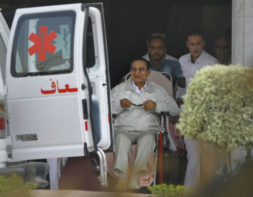 Former Egyptian President Hosni Mubarak (seated), 85, is escorted by medical and security personnel into an ambulance to be taken by helicopter ambulance from Maadi Military Hospital to the Cairo Police Academy for trial on Sunday, Aug. 25, 2013, in Cairo. Mr. Mubarak, under house arrest after being released from detention last week, is being retried on charges of complicity in the killings of protesters during the 2011 Egyptian uprising. (AP Photo/Amr Nabil)