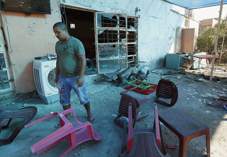 A man inspects the aftermath of a bomb attack at a coffee shop in the northeastern Shaab neighborhood of Baghdad, Iraq, Monday, Aug. 26, 2013. (AP Photo/Hadi Mizban)