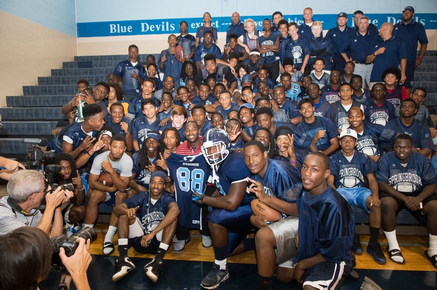Redskins receiver Pierre Garcon poses with players on the Springbrook High School football team after providing them with new uniforms on Aug. 20, 2013 as part of his partnership with Russell Athletic.