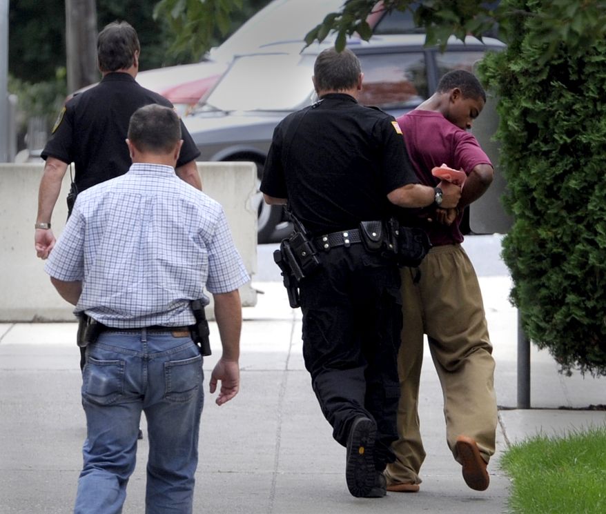 Demetrius Glenn (right), a teen who allegedly took part in the robbery and beating of 88-year-old World War II veteran Delbert Belton, is moved swiftly back to the juvenile detention center near the Spokane County Courthouse after a first appearance, via video, in District Court in Spokane, Wash., on Monday, Aug. 26, 2013. The youth, who will be charged as an adult, is charged with first-degree murder and first-degree robbery and was ordered held on $2 million bail. (AP/The Spokesman-Review, Jesse Tinsley)