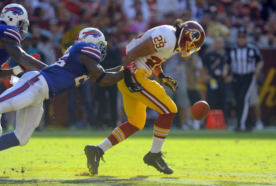 Washington Redskins running back Roy Helu (29) loses hold of the ball as he is tackled by Buffalo Bills strong safety Da'Norris Searcy in the first half of an NFL preseason football game Saturday, Aug. 24, 2013, in Landover, Md. Helu regained possession of the ball on the play. (AP Photo/Richard Lipski)