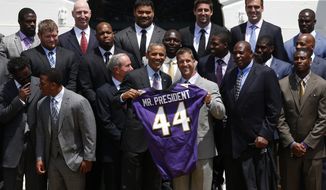 **FILE** President Obama poses with a personalized Baltimore Ravens football jersey with Ravens head coach John Harbaugh during a ceremony on the South Lawn of the White House on June 5, 2013, where the president honored the Super Bowl XLVII champs. The Ravens defeated the San Francisco 49ers in Super Bowl XLVII in February. (Associated Press)