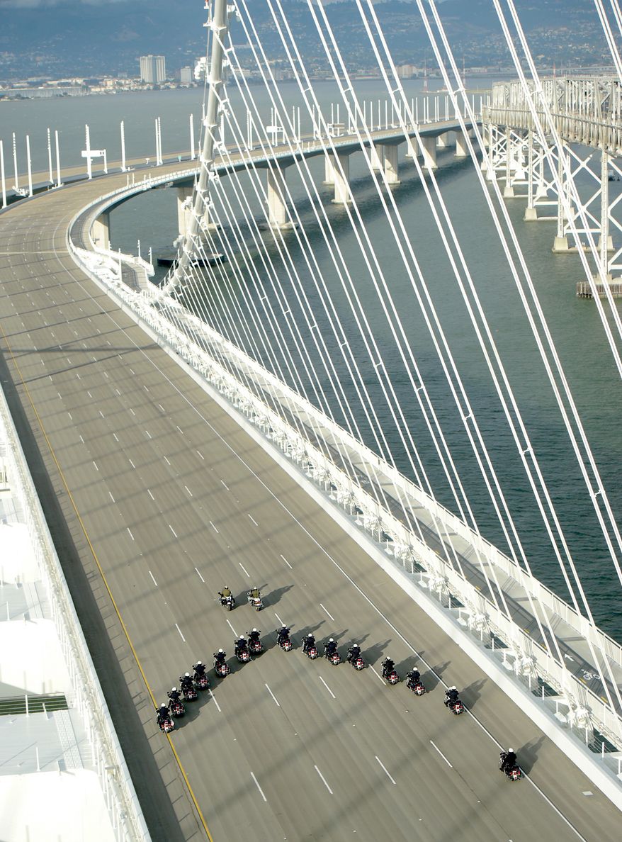 In this photo taken on Monday, Sept. 2, 2013, provided by the Bay Area Toll Authority, a phalanx of police officers cross the San Francisco-Oakland Bay Bridge after leading a procession marking the east span's opening, in San Francisco. At the modest inaugural ceremony, the new, self-anchored suspension bridge with its looming, single white tower was praised as a dramatic safety upgrade over its predecessor. (AP Photo/Bay Area Toll Authority, Noah Berger)