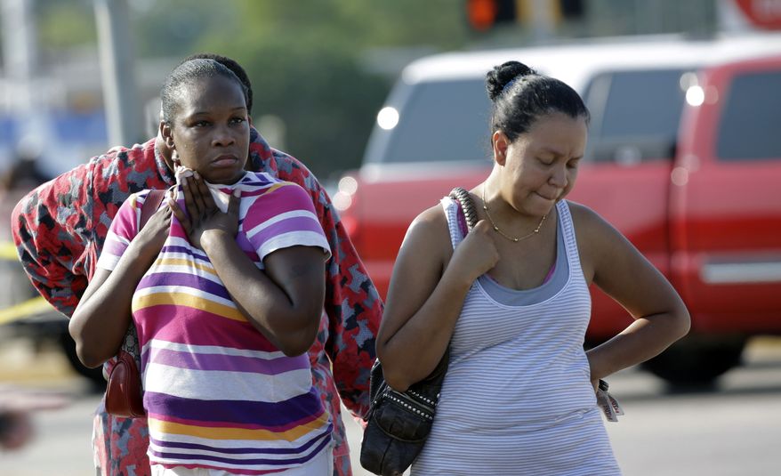 Eunice Pacheco (right) and LaKesia Brent wait for news about their children outside Spring High School on Wednesday, Sept. 4, 2013, in Spring, Texas, after a stabbing incident in the school cafeteria. (AP Photo/David J. Phillip)