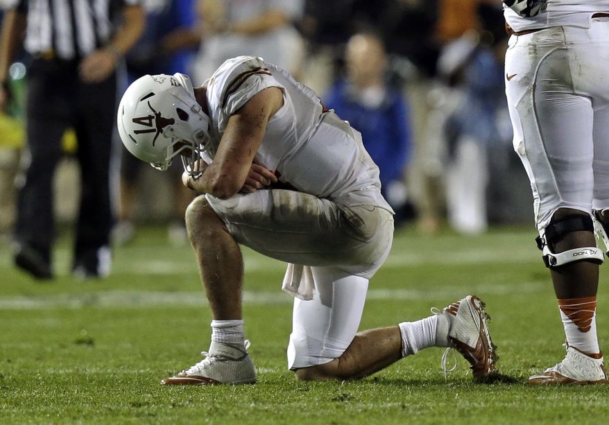 Texas quarterback David Ash (14) takes a knee after being injured following a tackle in the fourth quarter NCAA college football game against Brigham Young Saturday, Sept. 7, 2013, in Provo, Utah. BYU defeated Texas 40-21. (AP Photo/Rick Bowmer)
