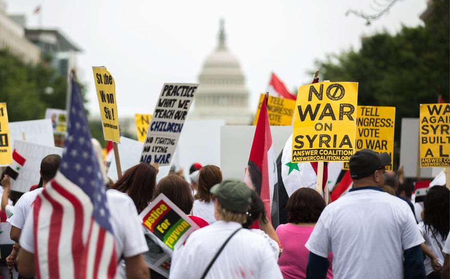 Anti-war activists march down Pennsylvania Avenue to voice opposition to proposed U.S. involvement in the Syrian civil war. (Andrew S. Geraci/The Washington Times)
