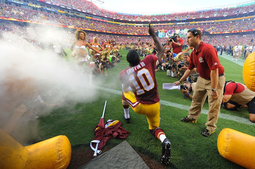 Washington Redskins quarterback Robert Griffin III (10) kneels on the field and points to the heavens as he's introduced for the first time in the 2013 season before the Washington Redskins play the Philadelphia Eagles in Monday Night NFL football at FedExField, Landover, Md., Monday, September 9, 2013. (Preston Keres / For The Washington Times)