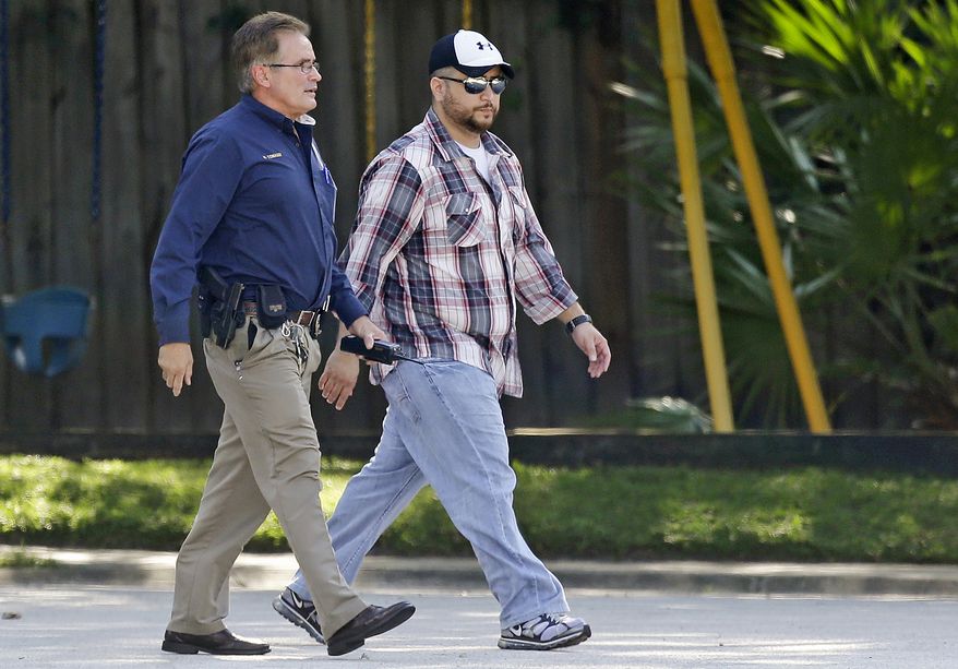 ** FILE ** George Zimmerman (right) is escorted to a home by a Lake Mary police officer on Sept. 9, 2013, in Lake Mary, Fla., after a domestic incident in the neighborhood where Zimmerman and his wife Shellie had lived during his murder trial. Zimmerman was recently found not guilty for the 2012 shooting death of Trayvon Martin. (Associated Press)