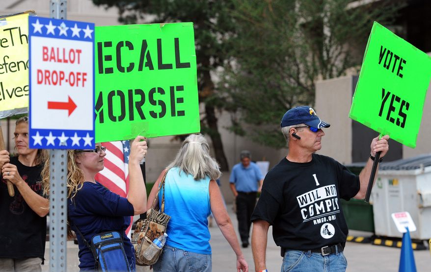 Protesters in favor of recalling Colorado state Sen. John Morse try to influence early voters in a recall election on Monday, Sept. 9, 2013, in Colorado Spring, Colo. Mr. Morse, who is Senate president, and state Sen. Angela Giron in Pueblo, both of whom voted for new Colorado firearms restrictions, faced the first legislative recalls in state history Tuesday. (AP Photos/The Colorado Springs Gazette, Jerilee Bennett)