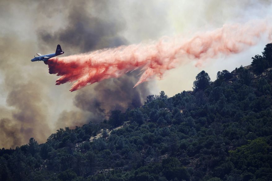A bomber drops retardant on a wildfire in Mount Diablo State Park on Monday, Sept. 9, 2013, in Contra Costa County, Calif. The blaze forced dozens of residents and animals to evacuate Monday. (AP Photo/Marcio Jose Sanchez)