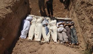 This authenticated image from Aug. 21 purports to show several bodies being buried during a funeral in a suburb of Damascus after a chemical weapon was used against civilians. (Shaam News Network via Associated Press)