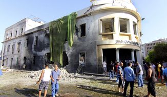 People gather to look at the site of a car bombing near Libya’s Foreign Ministry building in Benghazi, Libya, on Sept. 11, 2013, one year to the date of an attack there killed the U.S. ambassador and three other Americans. (Associated Press)