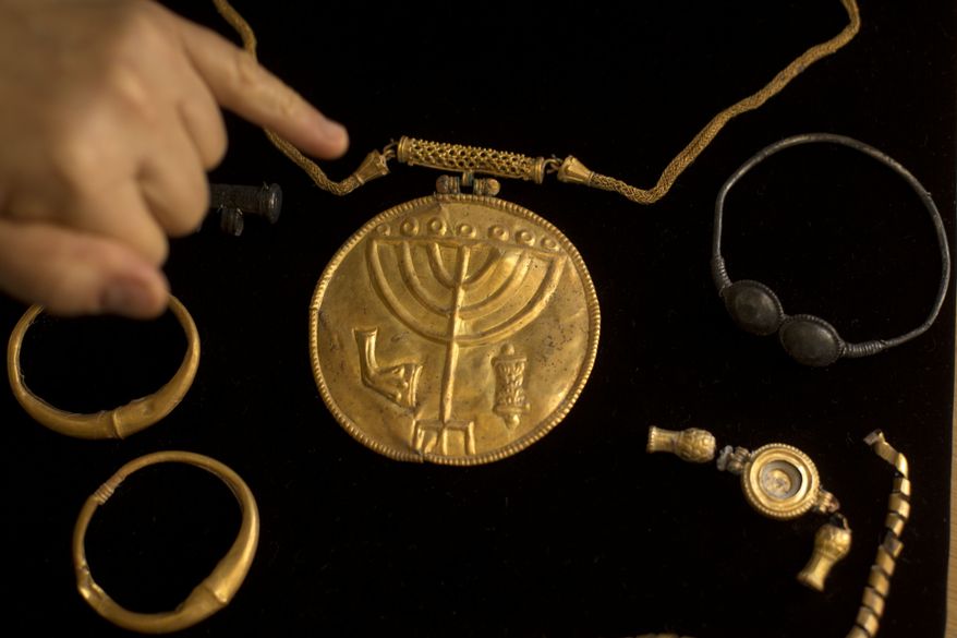 Jewelry and a gold medallion with the Jewish menorah symbol etched into it is shown during a press conference at the Hebrew University in Jerusalem, Monday, Sept. 9, 2013. An Israeli archaeologist says she has uncovered a rare trove of ancient coins and medallions near Jerusalem's Temple Mount. (AP Photo/Sebastian Scheiner)