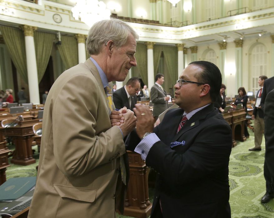 Assemblyman Luis Alejo, D-Watsonville, right, is congratulated by Assemblyman Roger Dickinson after the Assembly approved Alejo's minimum wage bill at the Capitol in Sacramento, Calif., Thursday, Sept. 12, 2013. The bill, AB10, which would raise the minimum wage from the current $8 an hour to $10 by 2016, now goes to the governor. (AP Photo/Rich Pedroncelli)