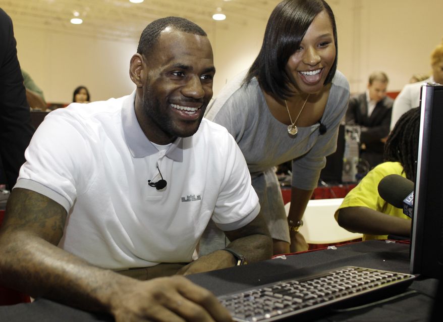 FILE - In a March 2, 2011 file photo, Miami Heat basketball player LeBron James, center, sits with his girlfriend Savannah Brinson, right, at a new computer during a charity event at the Northwest Boys & Girls Club in Miami. James married Savannah Brinson at the posh Grand Del Mar Hotel in San Diego on Saturday, Sept. 15, 2013, according to two people familiar with the details of the ceremony. About 200 guests were present for the ceremony, said one of the people, both of whom spoke on condition of anonymity because the wedding was private and the couple had yet to release any details. James and Brinson, 27, have been together since high school and have two sons. (AP Photo/Lynne Sladky, File)