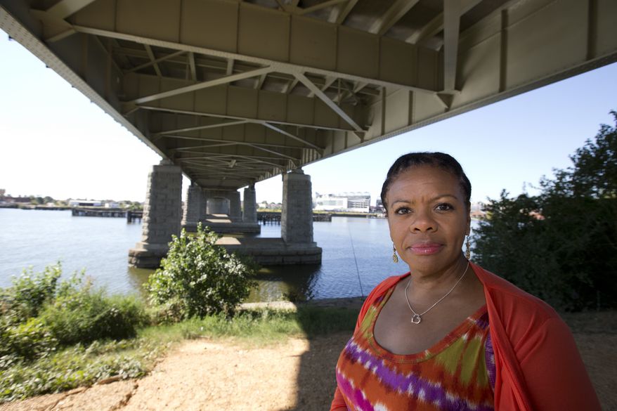 Alesia Tisdall stands for a photograph under the Frederick Douglass Memorial Bridge which spans the Anacostia River in Washington on Friday, Sept. 6, 2013. Tisdall, who drove daily over the bridge for 15 years but now crosses it only occasionally, said she found it unnerving that the bridge would "bounce" in the middle as she sat in bumper-to-bumper traffic. (AP Photo/Alex Brandon)