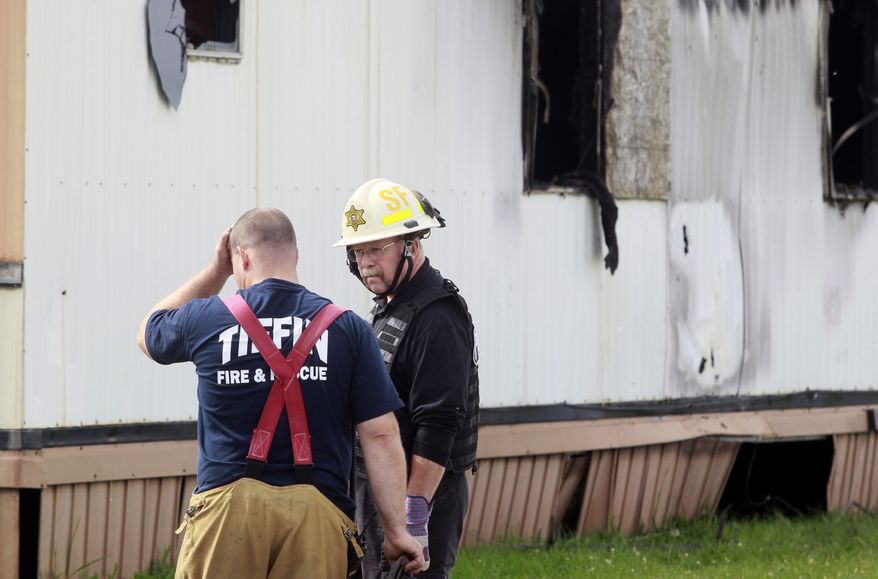 William Timothy Spradlin (right), chief of the Ohio Fire and Explosion Investigation Bureau, speaks with a member of the Tiffin Fire/Rescue Division during the investigation into a fire that killed five children and one adult on Sunday, Sept. 15, 2013, in Tiffin, Ohio, about 50 miles southeast of Toledo. (AP Photo/The Blade, Amy Voigt)