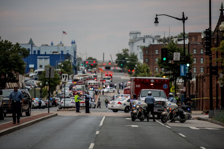 Swarms of police stand outside the Navy Yard as workers are evacuated from the area as police search for a gunman, in Washington, D.C., Monday, Sept. 16, 2013. (Andrew S. Geraci/The Washington Times)