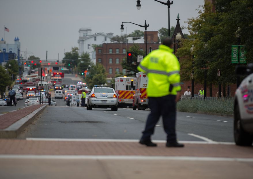 Swarms of police stand outside the Navy Yard as workers are evacuated from the area as police search for a gunman, in Washington, D.C., Monday, Sept. 16, 2013. (Andrew S. Geraci/The Washington Times) ** FILE **