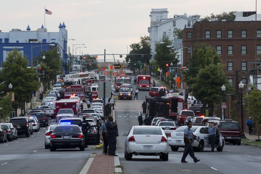 Police work the scene on M Street Southeast in Washington after a gunman was reported at the Washington Navy Yard on Monday, Sept. 16, 2013. (AP Photo/Jacquelyn Martin)