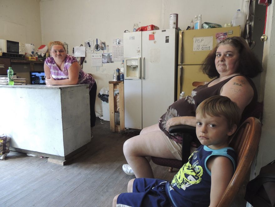 **FILE** Renee Adams (left) poses with her mother, Irene Salyers, and son, Joseph, 4, at their produce stand in Council, Va., on July 12, 2013. Four out of five U.S. adults struggle with joblessness, near poverty or reliance on welfare for at least parts of their lives, a sign of deteriorating economic security and a vanishing American Dream amid rising incidences of hardship among whites. (Associated Press)