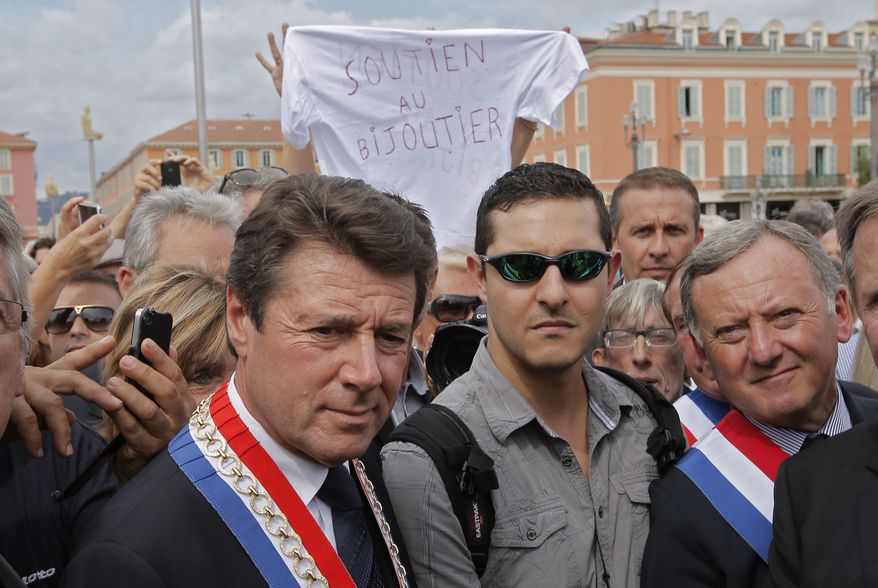 Christian Estrosi (left), mayor of Nice, France; Yann Turk (center), son of Nice jeweler Stephan Turk; and elected city officials take part in a rally supporting the elder Mr. Turk on Monday, Sept. 16, 2013. Outrage is growing over the decision to bring manslaughter charges against the jeweler, 67, who was confined at home with an electronic bracelet after the shooting last week that left a teenage robber dead in the street outside Mr. Turk's jewelry store. An accomplice escaped on a motorbike. (AP Photo/Lionel Cironneau)