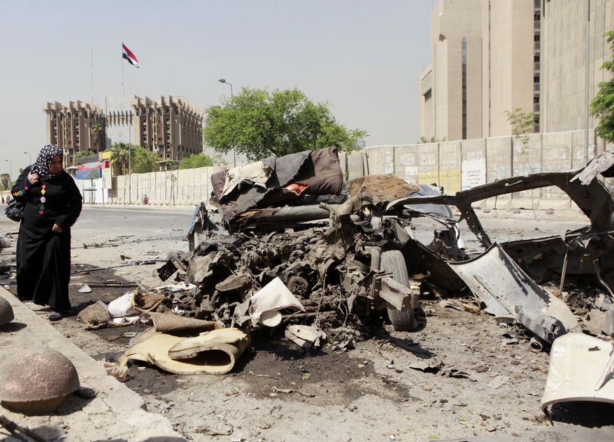 A woman inspects the site of a car bomb attack in front of the Ministry of Higher Education and Scientific Research in central Baghdad on Sept. 18, 2013. More than 4,000 people have been killed since April, including more than 800 just in August, according to U.N. figures. (Associated Press)