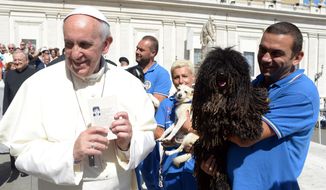 Pope Francis is shown a dog by a member of the Federazione Italiana Sport Cinofili (Italian Federation of Canine Sports) following his weekly general audience at the Vatican on Wednesday, Sept. 18, 2013. (AP Photo/L&#39;Osservatore Romano)