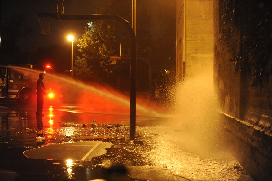 The Chicago Fire Department hoses down the scene where a number of people, including a 3-year-old child, were shot in a city park on the south side of Chicago, Thursday, Sept. 19, 2013. Authorities said no one has been taken into custody in connection with the shooting. (AP Photo/Paul Beaty)