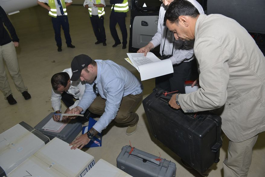** FILE ** In this file photo released Saturday Aug. 31, 2013, by the Organization for the Prohibition of Chemical Weapons, samples brought back by the U.N. chemical weapons inspection team are checked in upon their arrival at The Hague, Netherlands. Syria has sent the Organization for the Prohibition of Chemical Weapons an "initial declaration" outlining its weapons program, the organization said Friday Sept. 20, 2013. (AP Photo/OPCW, Henry Arvidsson, File)