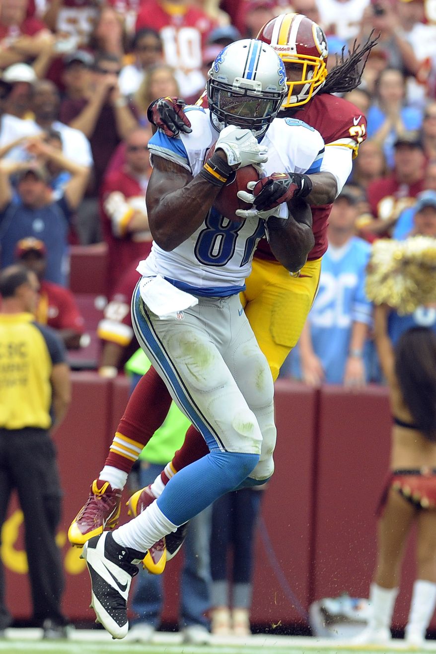 Detroit Lions wide receiver Calvin Johnson pulls in a touchdown pass under pressure from Washington Redskins strong safety Brandon Meriweather during the second half of a NFL football game in Landover, Md., Sunday, Sept. 22, 2013. (AP Photo/Richard Lipski)