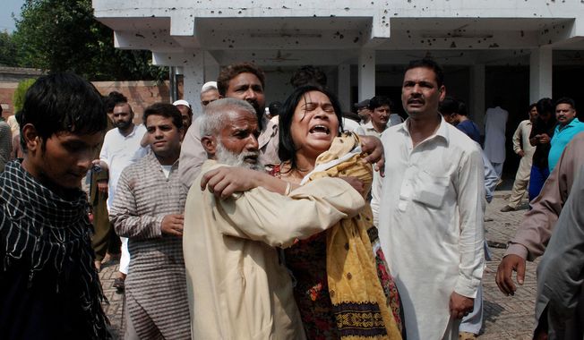 A Pakistani Christian woman mourns the death of her relatives at the site of a suicide attack on a church in Peshawar, Pakistan, on Sunday, Sept. 22, 2013. The bombing was in one of the worst assaults on the country’s Christian minority in years. (AP Photo/Mohammad Sajjad)