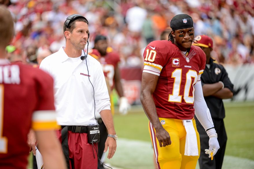 Washington Redskins offensive coordinator Kyle Shanahan, left, talks with Washington Redskins quarterback Robert Griffin III (10) on the sideline after Griffin threw an interception in the second quarter as the Washington Redskins play the Detroit Lions in NFL football at FedExField, Landover, Md., Monday, September 9, 2013. (Andrew Harnik/The Washington Times)