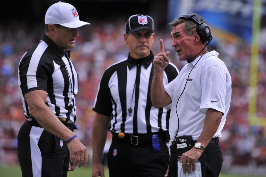 Washington Redskins head coach Mike Shanahan argues a second-quarter holding call with referee Ed Hochuli (L)as the Washington Redskins play the Detroit Lions at FedExField, Landover, Md., September 22, 2013. (Preston Keres/Special for The Washington Times)