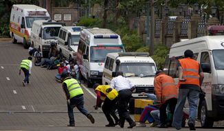 Paramedics run beside parked ambulances outside the Westgate Mall in Nairobi after heavy shooting started for the third time since the morning Monday, Sept. 23, 2013. Kenya&#39;s military launched a major operation at the upscale Nairobi mall and said it had rescued &quot;most&quot; of the hostages being held captive by al-Qaeda-linked militants during the standoff. (AP Photo/Sayyid Azim)
