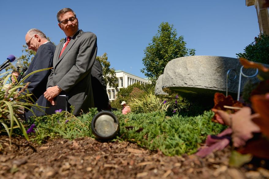 The Rev. Rob Schenck (right) of Faith and Action looks at the Ten Commandments sculpture that was knocked over by vandals. (Andrew Harnik/The Washington Times)