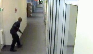 ** FILE ** Aaron Alexis was captured on video moving through the hallways of Building 197 at the Washington Navy Yard on Sept. 16 carrying a Remington 870 shotgun. FBI officials said he did not specifically target his shooting victims and was &quot;prepared to die.&quot; (FBI via Associated Press)