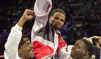 **FILE** William Joppy, of Silver Spring, Md., center, is raised aloft by his corner after he won the WBA middlweight championship bout against Howard Eastman, of England, at the Mandalay Bay resort in Las Vegas, Saturday, Nov. 17, 2001. Joppy won the fight by decision. (AP Photo/Mark J. Terrill)