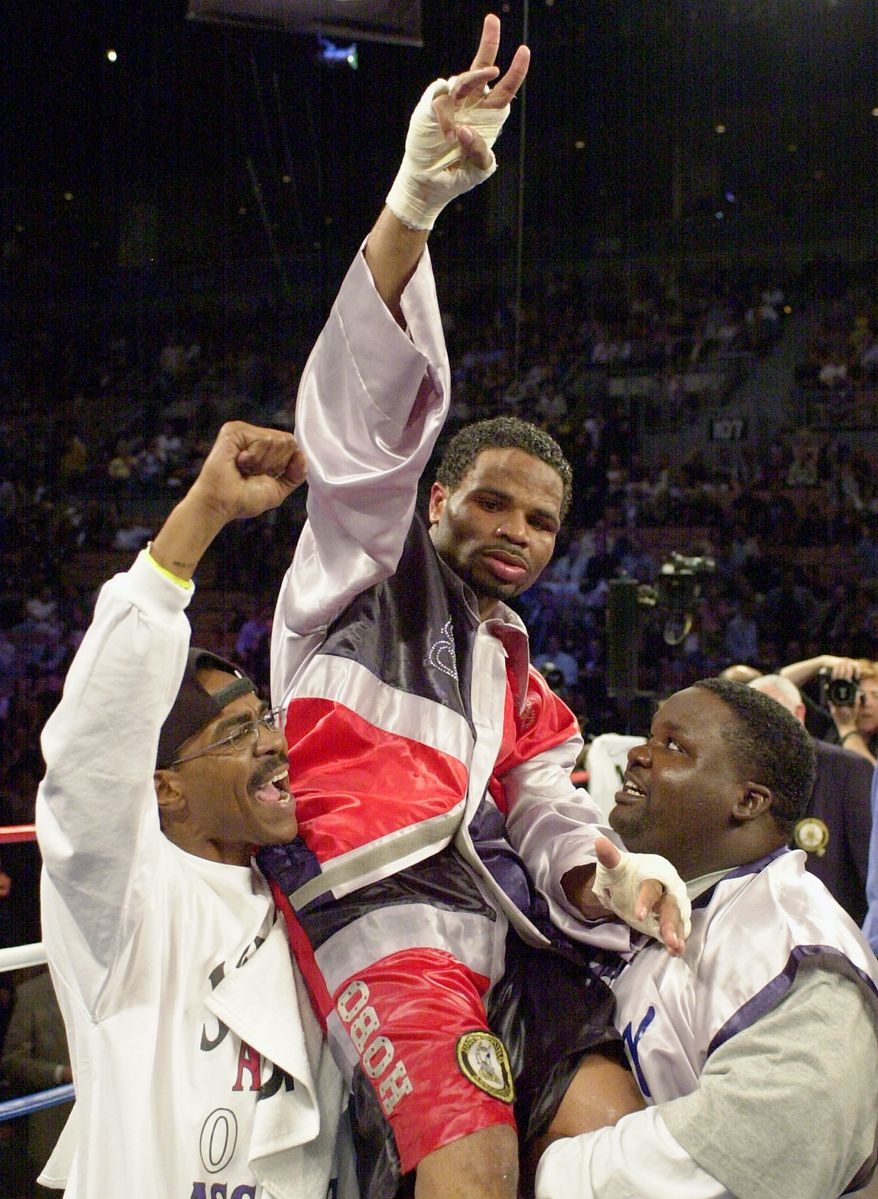 **FILE** William Joppy, of Silver Spring, Md., center, is raised aloft by his corner after he won the WBA middlweight championship bout against Howard Eastman, of England, at the Mandalay Bay resort in Las Vegas, Saturday, Nov. 17, 2001. Joppy won the fight by decision. (AP Photo/Mark J. Terrill)