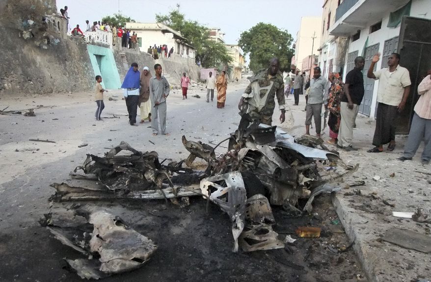 ** FILE ** Somalis observe the remains of a vehicle used in a car bomb attack in the capital Mogadishu, Somalia in this Wednesday, Feb. 8, 2012 file photo, an attack claimed by a spokesman for Somalia's al-Shabab Islamist insurgency. Al-Shabab have claimed responsibility for the gun and grenade attack on a shopping mall in Nairobi, Kenya, Saturday, Sept 21, which has left dozens dead and wounded, apparently in retaliation for Kenya's military participation in peace-keeping efforts in Somalia.(AP Photo/Farah Abdi Warsameh, file)