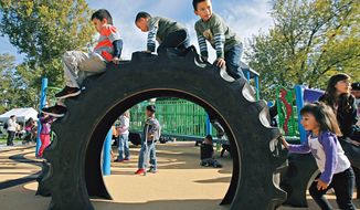 Children play on the new &quot;Tread Town&quot; playground during the grand opening of the certified Boundless Playground at Memorial Park in Pasco, Wash. (AP Photo/Tri-City Herald, Kai-Huei Yau) ** FILE ** 