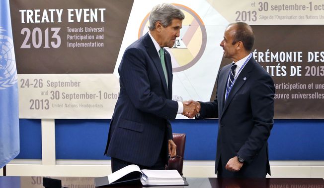 U.S. Secretary of State John Kerry, left, shakes hands with Under Secretary-General for Legal Affairs Miguel Serpa Soares after signing the Arms Trade Treaty during the 68th session of the United Nations General Assembly at U.N. headquarters, Wednesday, Sept. 25, 2013. (AP Photo/Jason DeCrow)