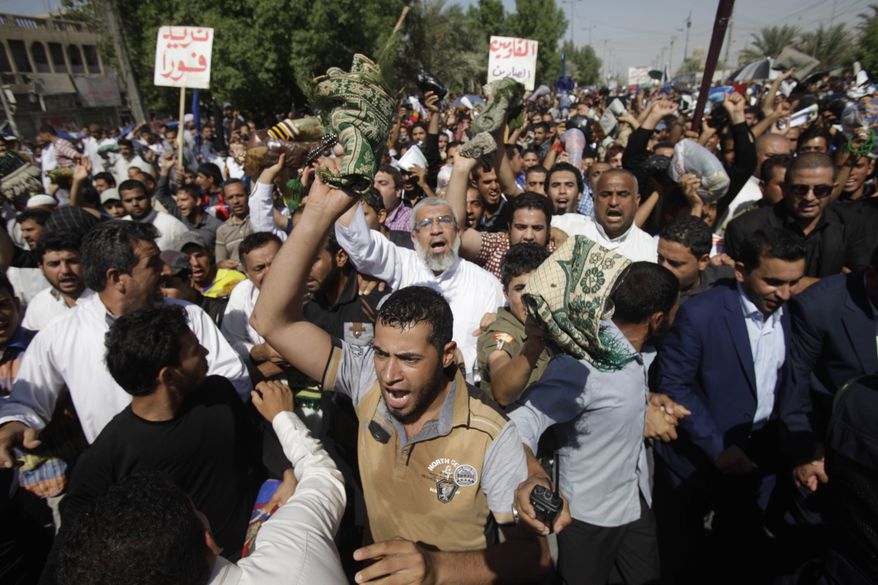 Iraqi followers of Shiite cleric Muqtada al-Sadr hold a demonstration in the Sadr City neighborhood of Baghdad on Friday, Sept. 27, 2013, to call for the release of detainees held by Iraqi authorities. (AP Photo/Karim Kadim)