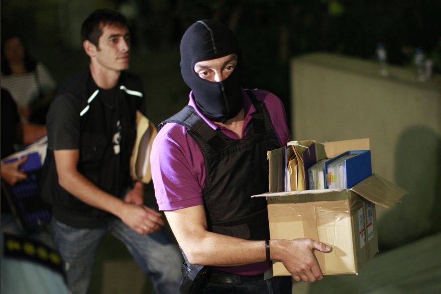 An anti-terror police officer carries a box containing the case file against the arrested suspects of the extreme far-right Golden Dawn party as he arrives at the court in Athens on Saturday, Sept. 28, 2013. Police arrested the leader and other top members of the party on Saturday in an escalation of a government crackdown after a fatal stabbing allegedly committed by a supporter. It is the first time since 1974 that sitting members of Parliament have been arrested. (AP Photo/Kostas Tsironis)