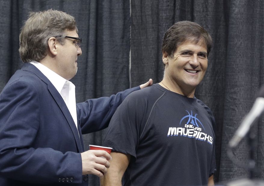 ** FILE ** Dallas Mavericks owner Mark Cuban (right) gets a pat on the back from Donn Nelson, president of basketball operations, before a news conference in Dallas on Thursday, Aug. 15, 2013. The government's insider-trading case against Cuban goes to trial on Monday, Sept. 30, 2013, in federal court in Dallas. (AP Photo/LM Otero)