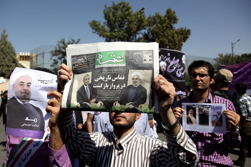 A supporter of Iranian President Hassan Rouhani holds a local newspaper with a headline that reads, "Historic call from a return flight," upon the leader's arrival from the U.S. on Saturday, Sept. 28, 2013, near the Mehrabad Airport in Tehran. Iranians from across the political spectrum hailed the historic phone conversation between President Obama and Mr. Rouhani, reflecting wide support for an initiative that has the backing of both reformists and the country's conservative clerical leadership. (AP Photo/Ebrahim Noroozi)