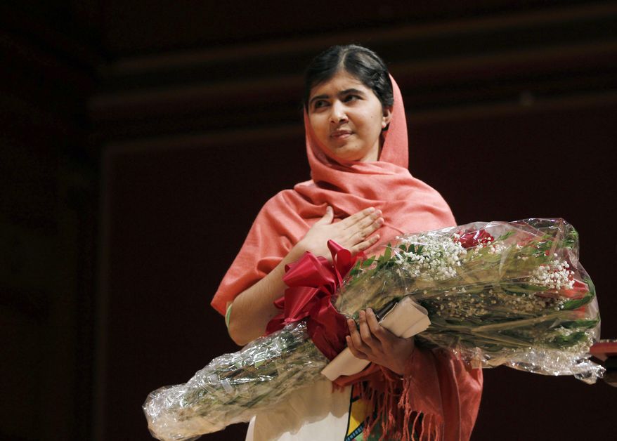 ** FILE ** Malala Yousafzai, gestures after receiving the 2013 Peter J. Gomes Humanitarian Award at Harvard University Friday, Sept. 27, 2013, on the school's campus in Cambridge, Mass. The Pakistani teenager, an advocate for education for girls, survived a Taliban assassination attempt last year on her way home from school. (AP Photo/Jessica Rinaldi)