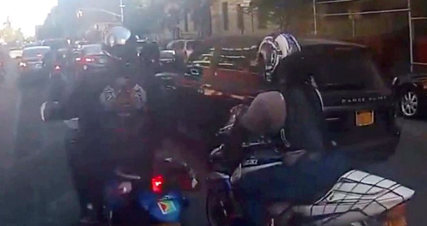 In this frame grab from video provided by the New York Police Department, motorcyclists ride alongside a sport utility vehicle on Sunday, Sept. 29, 2013, in New York. Police say that a man driving with his family along a New York City highway was attacked and beaten by a large group of motorcyclists who first surrounded his SUV, stopped it on the road and then chased him for miles after he plowed through the blockade of bikes in an attempt to escape. (AP Photo/New York Police Department)